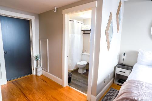 a bedroom with a bed and a bathroom with a toilet at Gunstock Inn & Suites in Gilford
