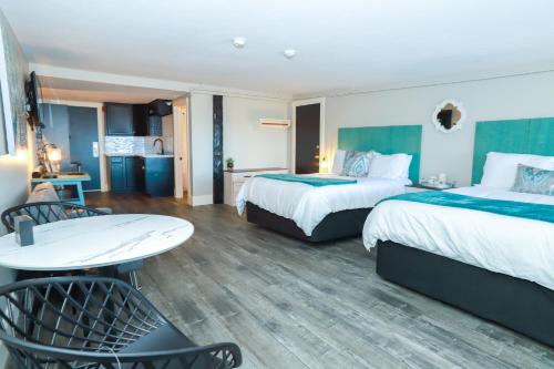 a hotel room with two beds and a table at Gunstock Inn & Suites in Gilford