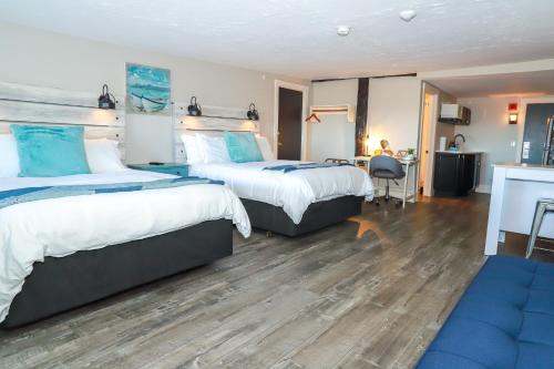 a hotel room with two beds and a desk at Gunstock Inn & Suites in Gilford