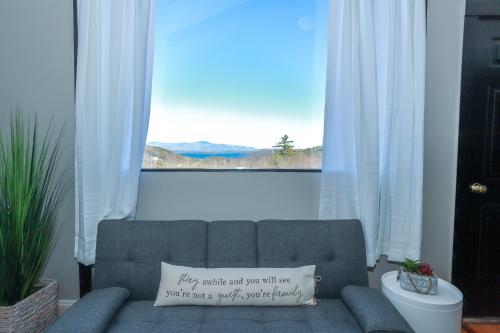 a couch in a living room with a window at Gunstock Inn & Suites in Gilford