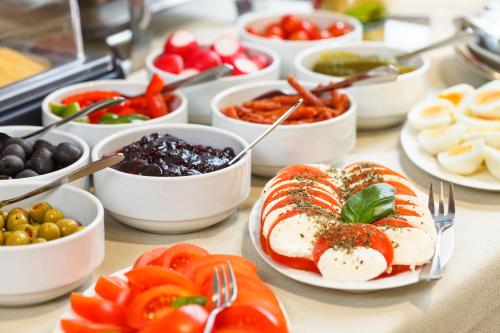 a table with plates of food and bowls of food at Hotel Czarna Róża in Toruń
