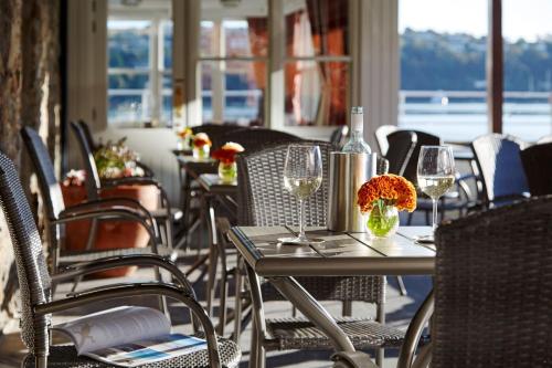 a dining room table with chairs and tables with umbrellas at Trident Hotel Kinsale in Kinsale