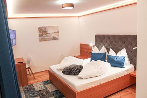 una camera da letto con un letto con cuscini blu e bianchi di Chalet Tolder a San Candido