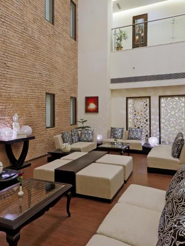 a living room with couches and a brick wall at Hotel DS Clarks Inn Gurgaon in Gurgaon