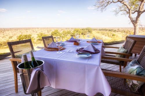 a table with a white table cloth and wine glasses at Klaserie Drift Misava in Klaserie Private Nature Reserve