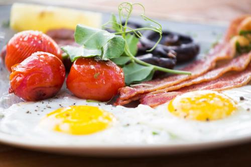 a plate of breakfast food with eggs bacon and toast at Klaserie Drift Misava in Klaserie Private Nature Reserve