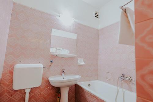 a bathroom with a sink and a toilet and a tub at Hotel Tusnad in Băile Tuşnad