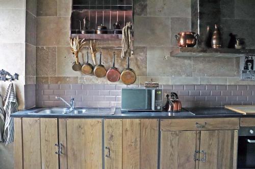 un comptoir de cuisine avec un évier et un micro-ondes dans l'établissement Le grand gîte du Sorcier ! Logement magique, à Colmar