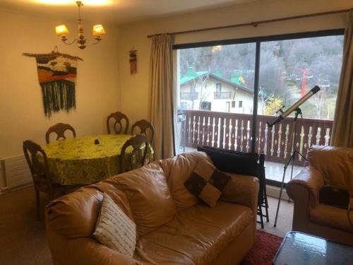 sala de estar con sofá, mesa y ventana en Apartamento Termas de Chillán, en Nevados de Chillán