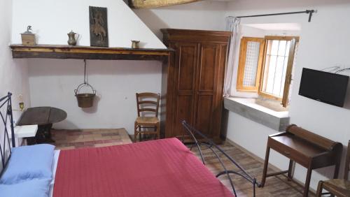 a room with a bed and a table and a television at B&B Il Pittore in Borgo San Lorenzo