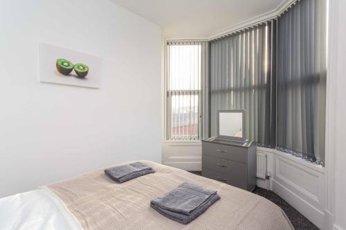 ein Schlafzimmer mit einem Bett mit zwei Handtüchern darauf in der Unterkunft Cherry Property - Kiwi Suite in Blackpool
