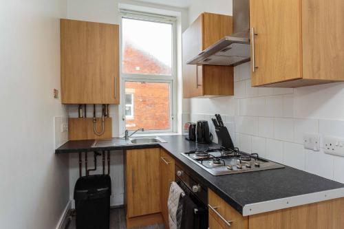 a kitchen with a stove and a sink and a window at Cherry Property - Kiwi Suite in Blackpool
