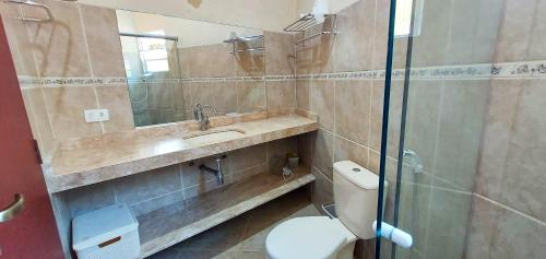 a bathroom with a toilet and a sink and a shower at Residencial Vitoria "Pé na Areia" in Ubatuba