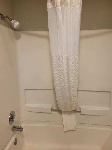 a white shower curtain hanging over a bath tub at Comfort Inn Cleveland Airport in Middleburg Heights