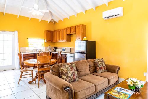 a living room with a couch and a kitchen at Chalk Sound Beach Residences Near Sapodilla Bay Beach by Angel Host! in Providenciales