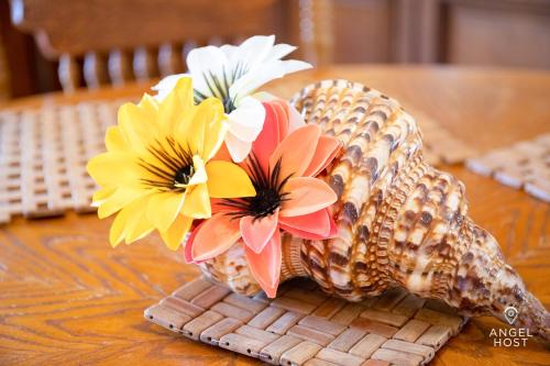 a vase with flowers in it on a table at Chalk Sound Beach Residences Near Sapodilla Bay Beach by Angel Host! in Providenciales