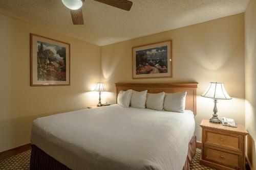 a bedroom with a large bed with two lamps on tables at Grand Lodge Condo in the Heart of Mt Crested Butte condo in Crested Butte