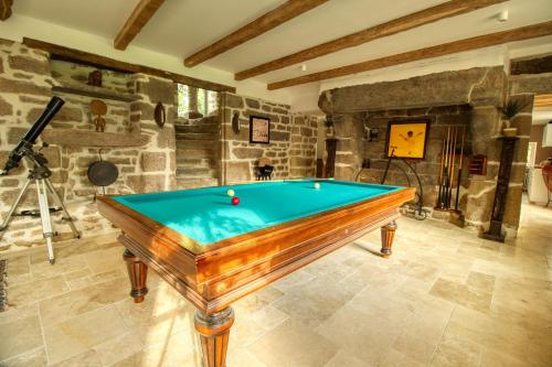 a pool table in the middle of a room at KERBELEG, ferme-manoir du XVè siècle, chambres grand confort in Riec-sur-Bélon