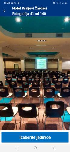 a lecture hall with chairs and a screen in the background at apartman Kraljevi čardaci Sadikovic sa garažom in Kopaonik