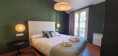 シエラネバダにあるIMEDA APARTAMENTO DORNAJOのベッドとタオル2枚のある寝室