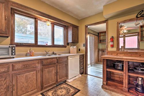 a kitchen with wooden cabinets and a sink and windows at Wildlife Lodge Columbia Retreat off I-70! in Columbia