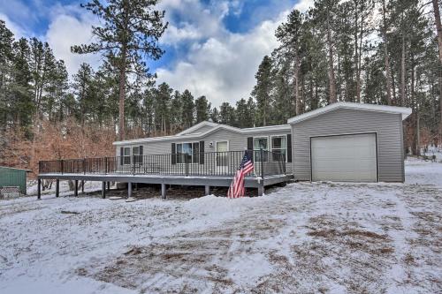 a house with a deck in the snow at Idyllic Sturgis Home with Fire Pit and Large Deck! in Sturgis