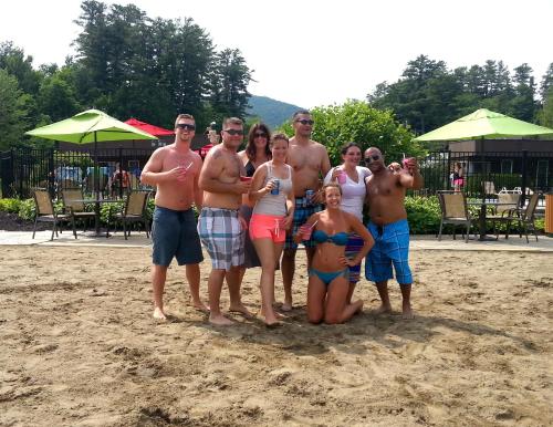 a group of people posing for a picture on the beach at Scotty's Lakeside Resort in Lake George