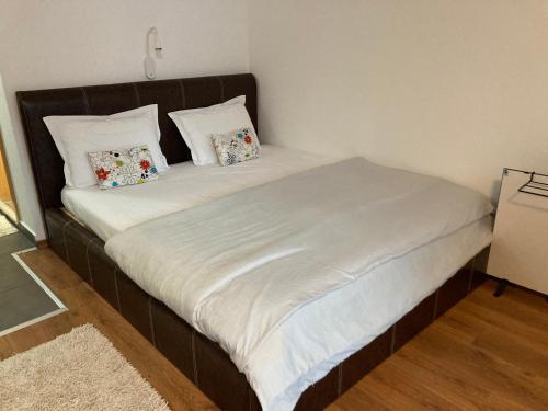 łóżko z białą pościelą i poduszkami w pokoju w obiekcie Studio Pirin Golf in Local Stay Bansko w mieście Razłog