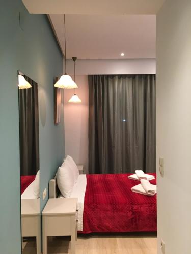 a bedroom with a bed with a red blanket at Family Studios in Marathias