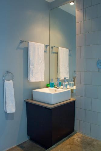 a bathroom with a white sink and a mirror at Lux Studio Apartment @ Hallmark House in Johannesburg