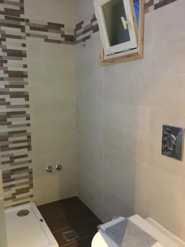 a bathroom with a toilet and a window on the wall at Family Studios in Marathias