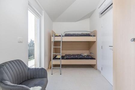 Una pequeña habitación con una litera y una silla. en Villa Manka, en Umag