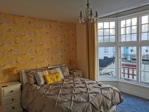 a bedroom with a bed and a large window at The Captains Quarters in Scarborough
