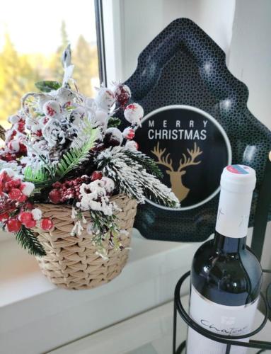 a basket of flowers next to a bottle of wine at Apartman Glacier in Tatranska Strba