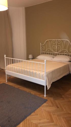 1 cama blanca en un dormitorio con alfombra en MyRoom CenterStation Bologna, en Bolonia