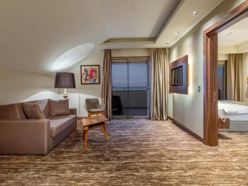 a hotel room with a couch and a bed at Holiday Inn Antalya - Lara by IHG in Antalya