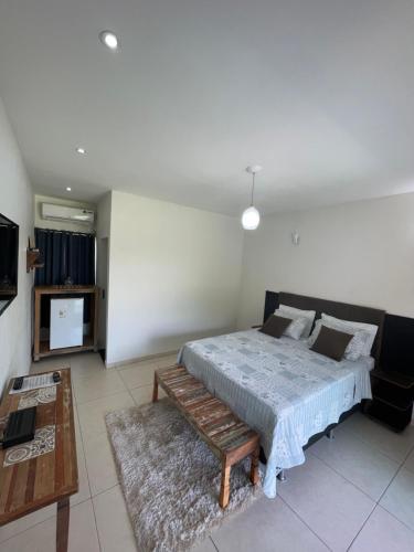 sypialnia z łóżkiem, ławką i telewizorem w obiekcie Pousada Yvanna w mieście Pirenópolis