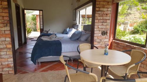 Schlafzimmer mit einem Bett, einem Tisch und Stühlen in der Unterkunft Hotel Suamena in Ráquira