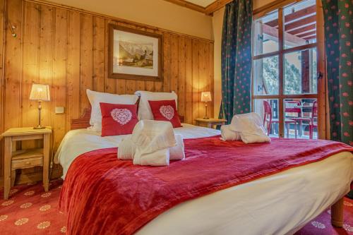 a bedroom with a large bed with red and white pillows at Le Refuge du Montagnard, Arc 1950, Skis aux pieds, Spa in Arc 1950