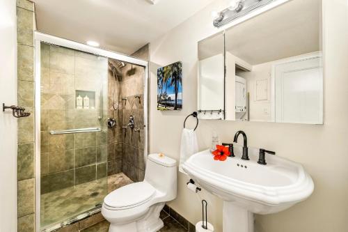 a bathroom with a toilet and a sink and a shower at Kona Mansions#302 in Kailua-Kona