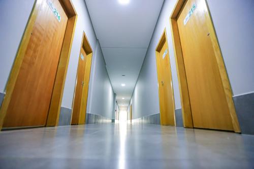 an empty hallway with wooden doors in a building at Vila Castelo Residencial no Centro de Foz in Foz do Iguaçu