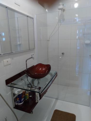 a bathroom with a glass sink and a shower at Apartamento da Maria Eunice in Poços de Caldas