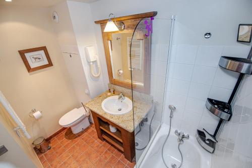 a bathroom with a sink and a tub and a toilet at Le Refuge du Montagnard, Arc 1950, Skis aux pieds, Spa in Arc 1950