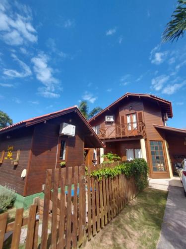 una casa con una valla de madera delante de ella en Long Life Campeche-Pousada en Florianópolis