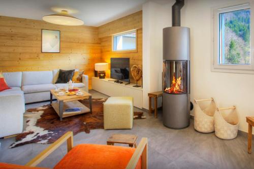 ein Wohnzimmer mit einem Sofa und einem Kamin in der Unterkunft Chalet Ysopi - OVO Network in Saint-Jean-de-Sixt