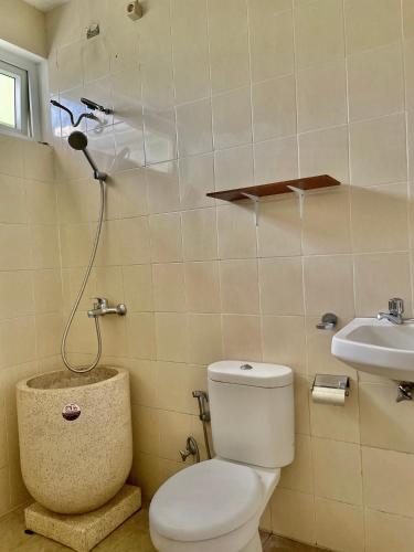 a bathroom with a toilet and a sink at Gerbera 4BR Villa Springhill Garden Malang in Malang