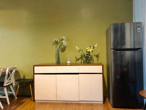 a white cabinet next to a refrigerator with flowers on it at Gerbera 4BR Villa Springhill Garden Malang in Malang