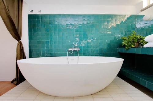 a bath tub in a bathroom with green tiles at Residenza Torre Vecchiarelli - apt 5 penthouse in Rome