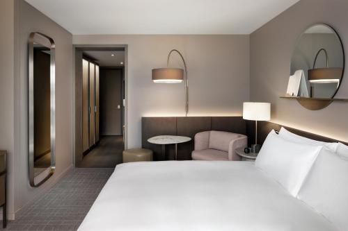 a hotel room with a bed and a chair at Fairmont Century Plaza Los Angeles at Beverly Hills in Los Angeles