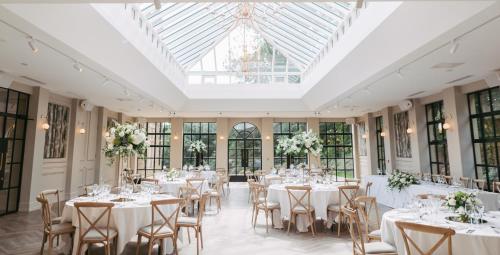 a room filled with tables and chairs with flowers at Woodlands Hotel in Leeds